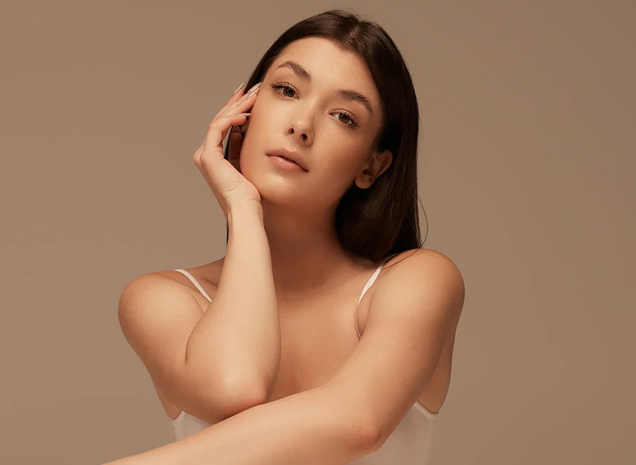 Woman with dark hair against a tan background - Hydrafacial in Chino, CA