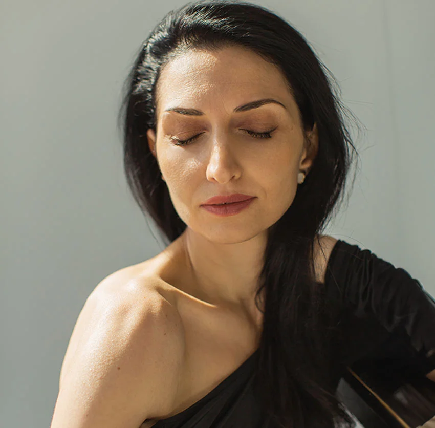 A woman with dark hair and an off-shoulder top sits with her eyes closed in a moment of tranquility - Mint Thread Facelift in Chino, CA